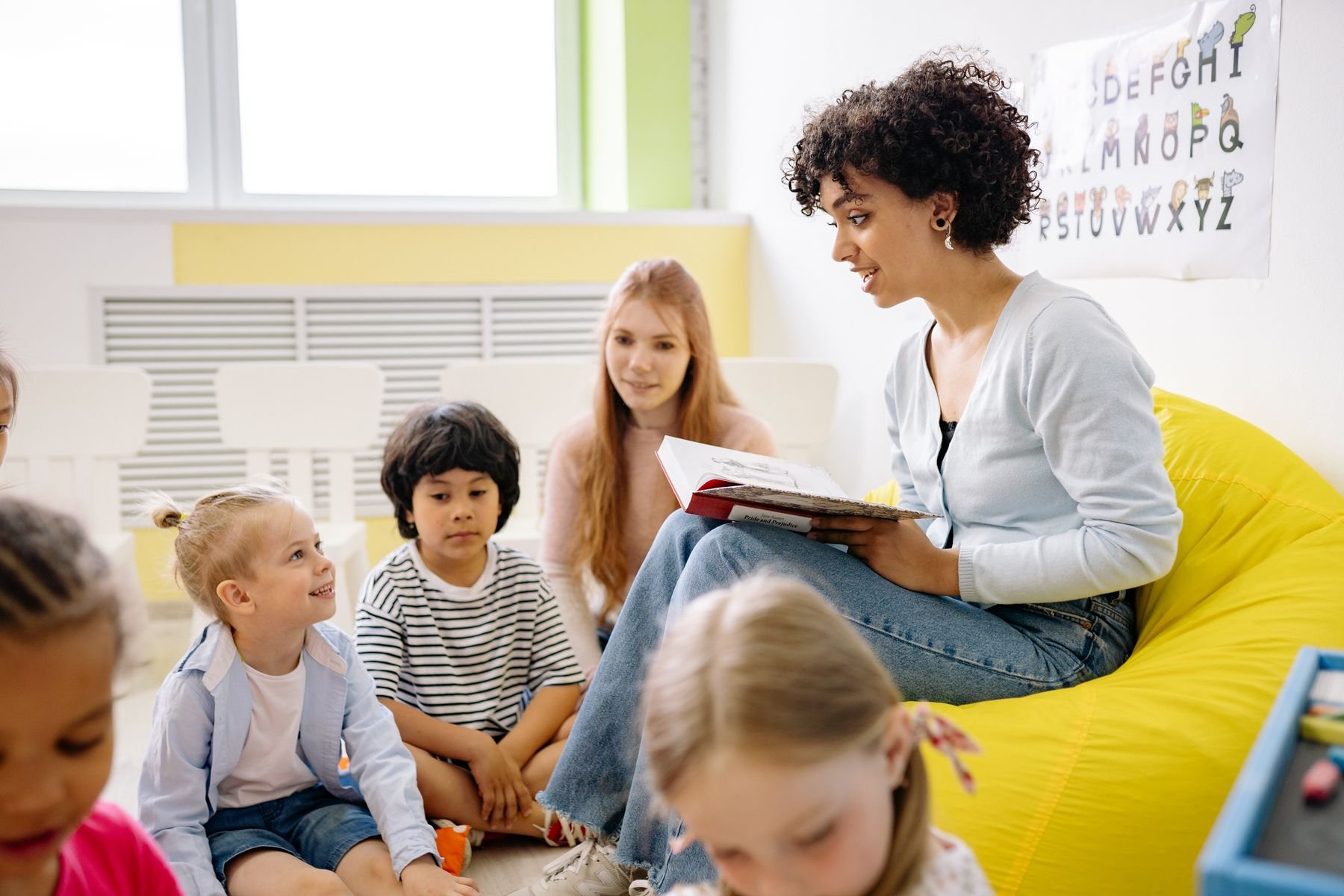 Preschool teacher reading to young children